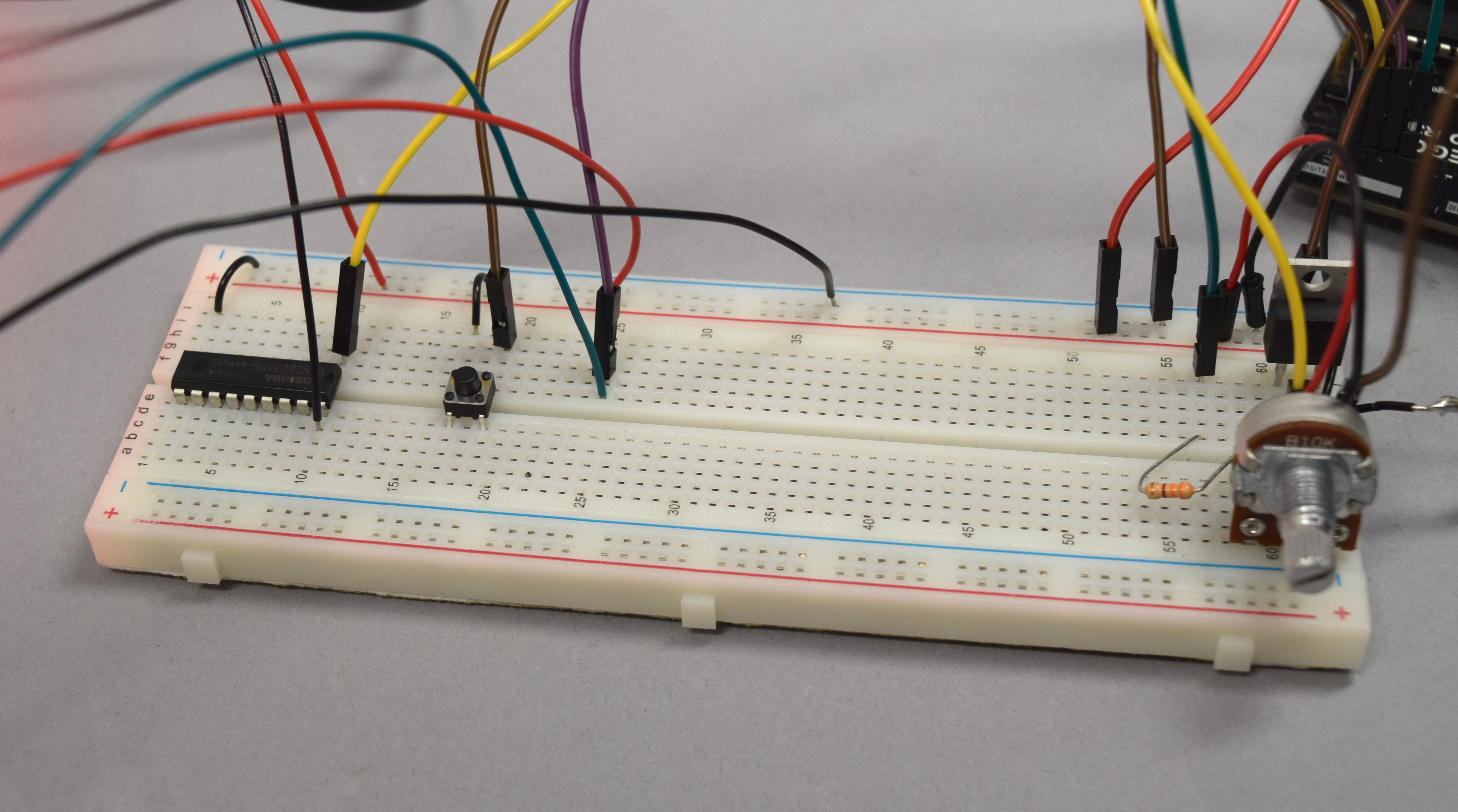 Breadboard that has a button to manually turn on the humidifier and a potentiometer that adjust the pump level