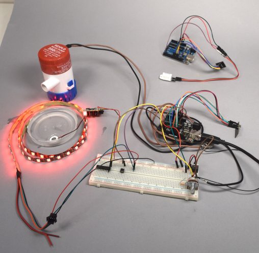 Our prototype has two separate parts: a fountain part (in the middle) with the pump, LED strip, humidifier and a radio receiver, and a remote part (top right) with a humidity detector and a radio sender.