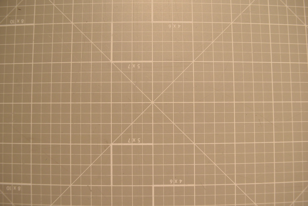 Image of orthogonal grid pattern showing noticeable "fisheye" effect: the center of the image has no distortion, but moving towards the edges the grid lines are bent out as if the image were wrapped around a sphere.