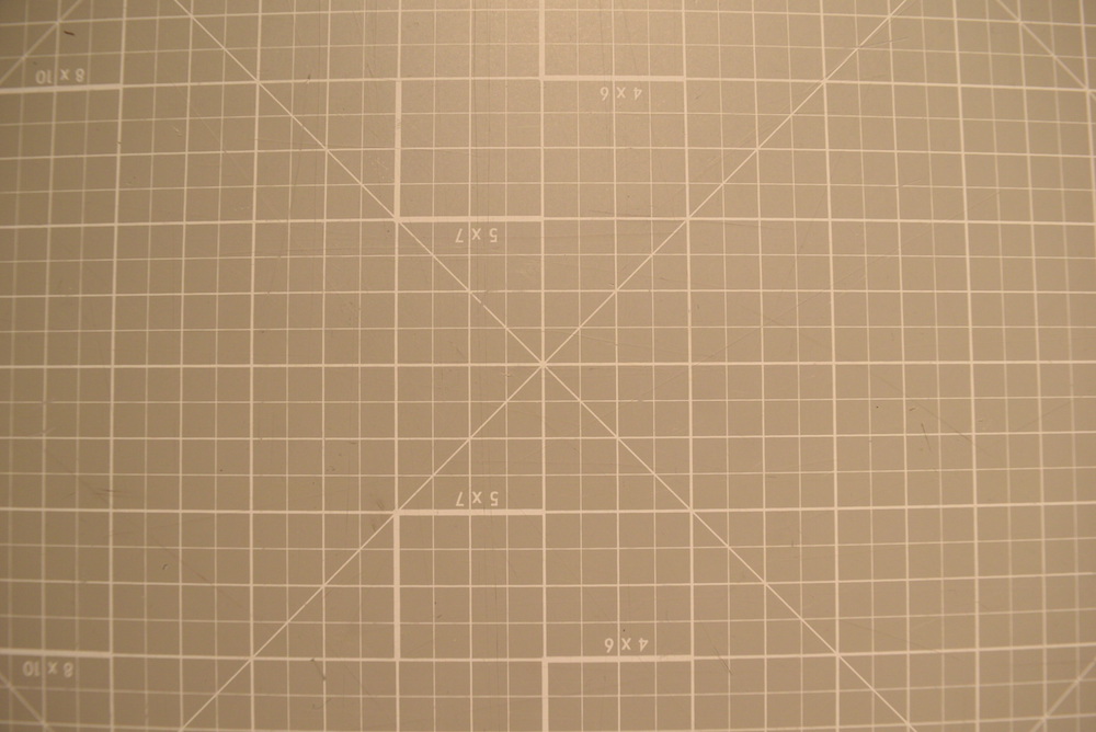 Image of orthogonal grid pattern showing noticeable "fisheye" effect: the center of the image has no distortion, but moving towards the edges the grid lines are bent out as if the image were wrapped around a sphere.