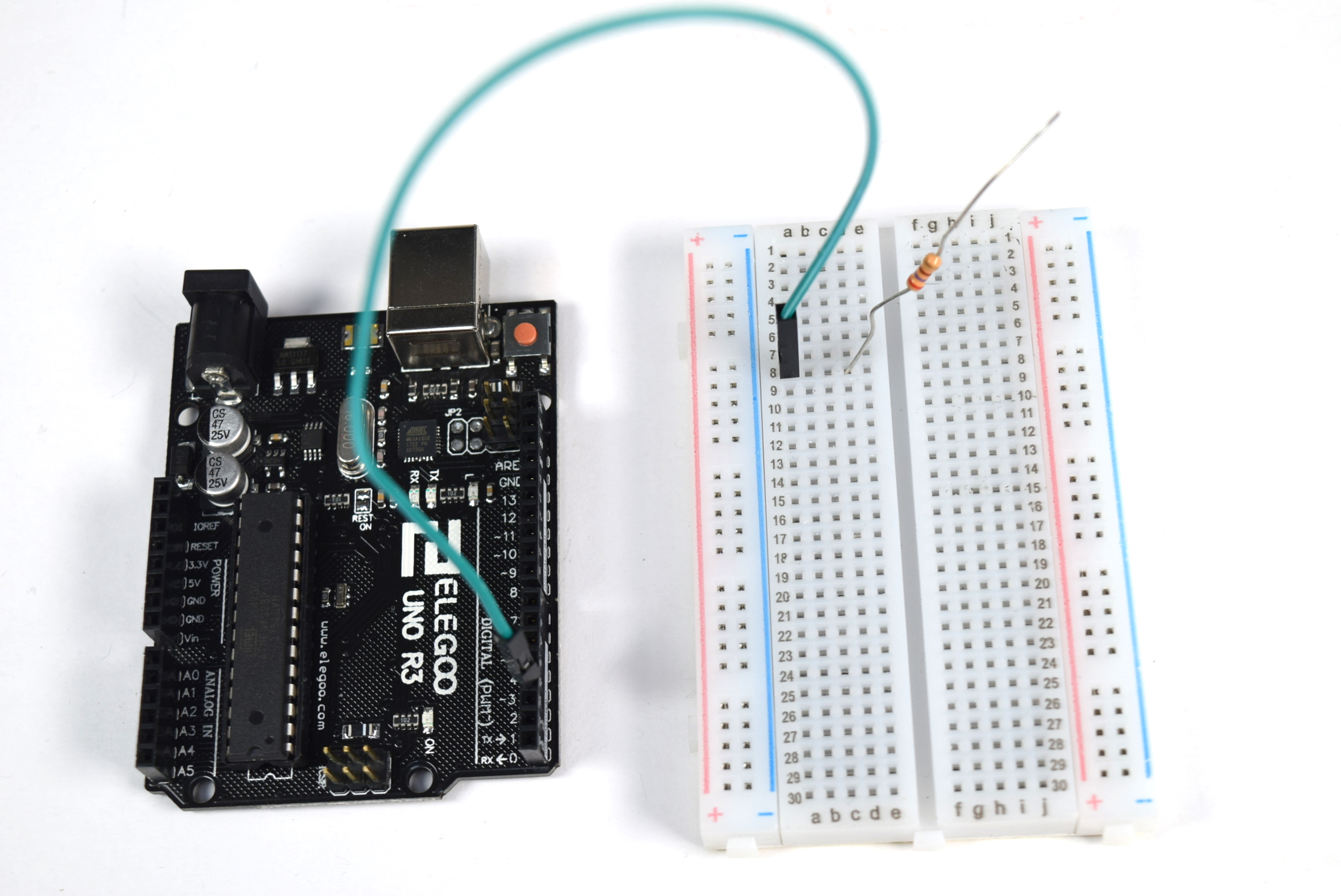 Photograph of a jumper going from Arduino pin 3 to position A8 on a medium sized breadboard, and one leg of a 270Ω resistor plugged into position D8