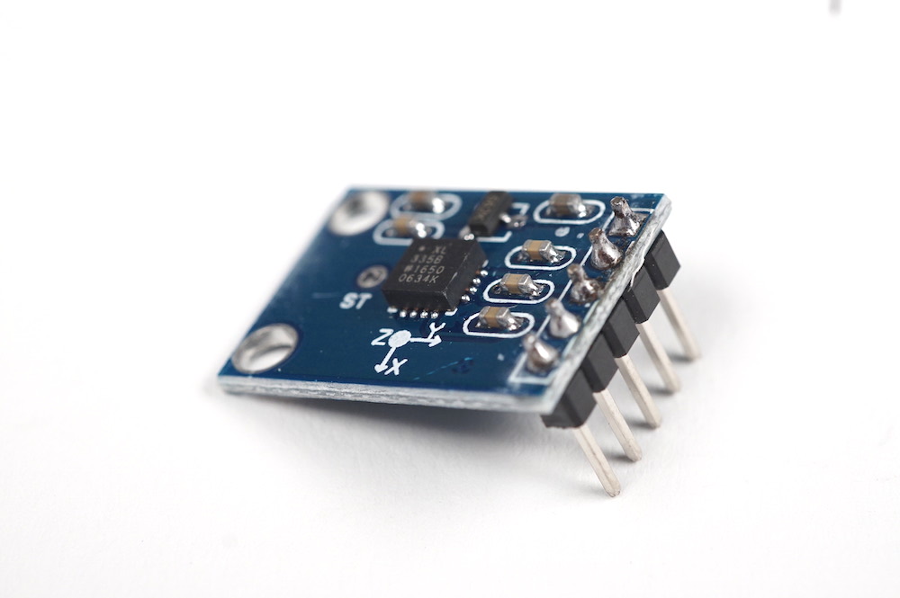 Image of ADXL335 sensor. It is a small PCB with five pins.