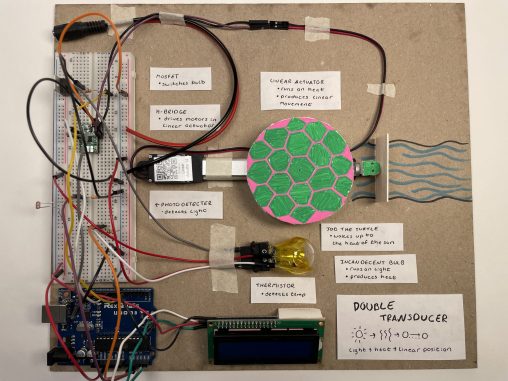 board with Arduino and electronic components, featuring a turtle attached to a linear actuator.