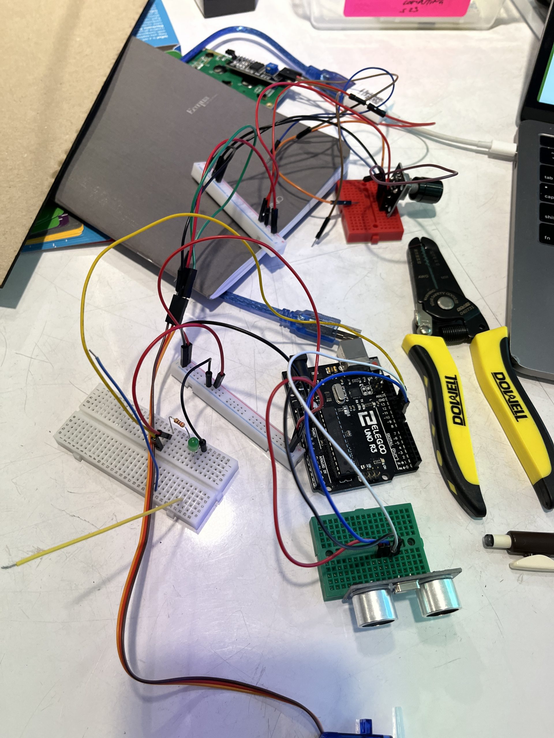 A mess of wires and breadboards, with an Arduino and ultrasonic ranger in the middle.