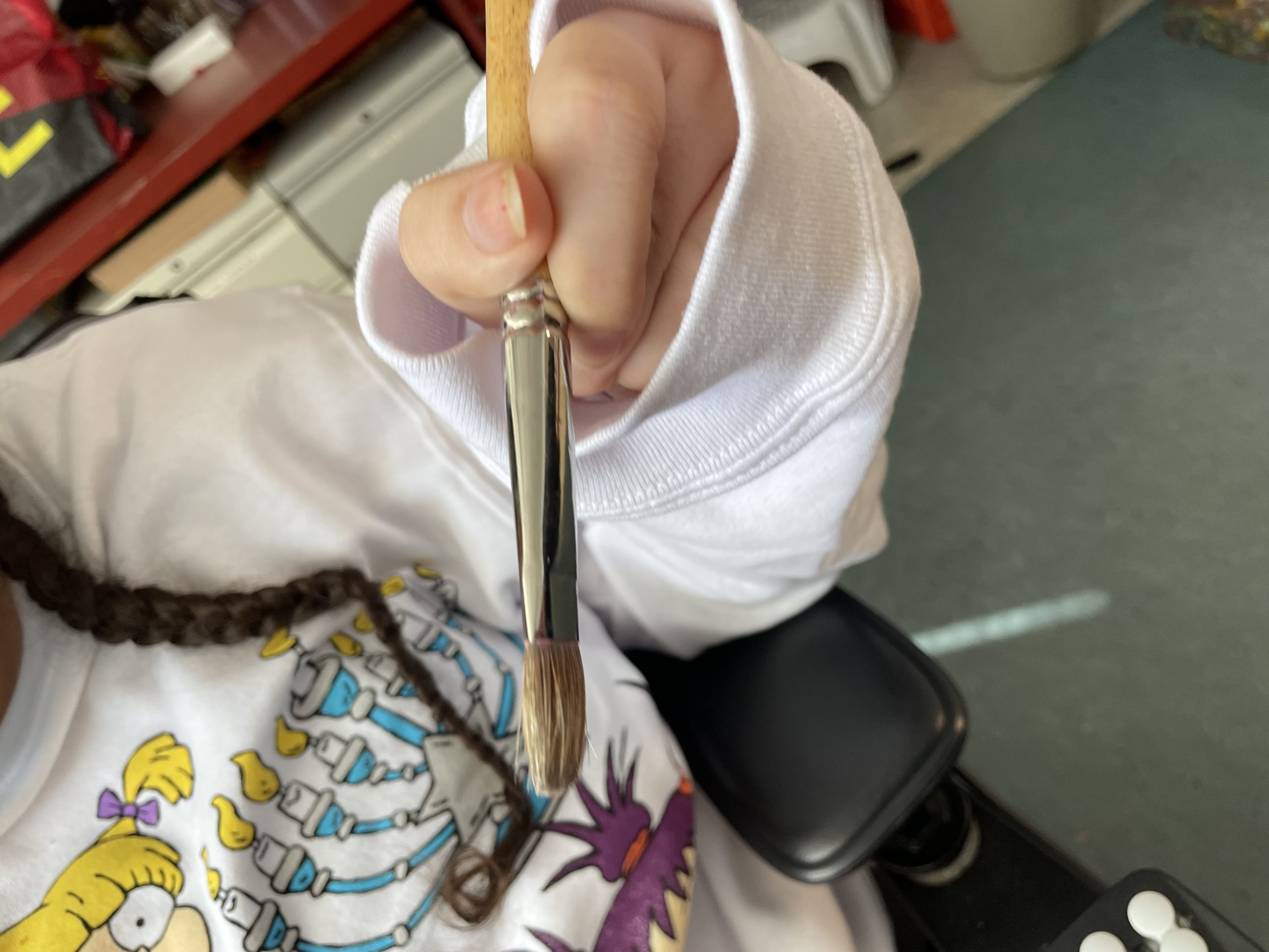 Shaude holding a paintbrush to show grip strength and positioning  