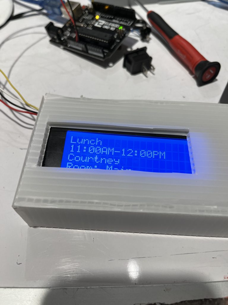 A white box with a bright blue LCD screen