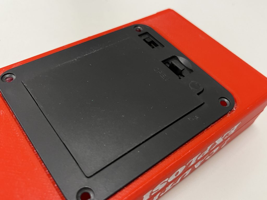 Red box with black battery compartment on the bottom
