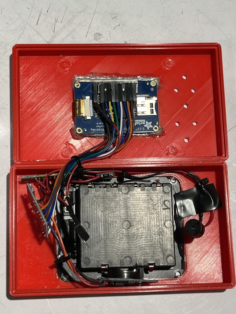 Red box with top and bottom split up containing electronic parts inside