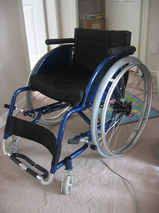 Lightweight blue wheelchair on carpet in a house.