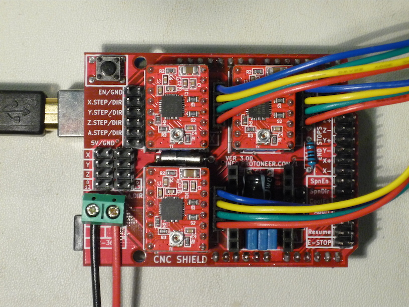 Top view of CNC Shield showing USB cable, power leads, A4988 drivers, and motor leads.